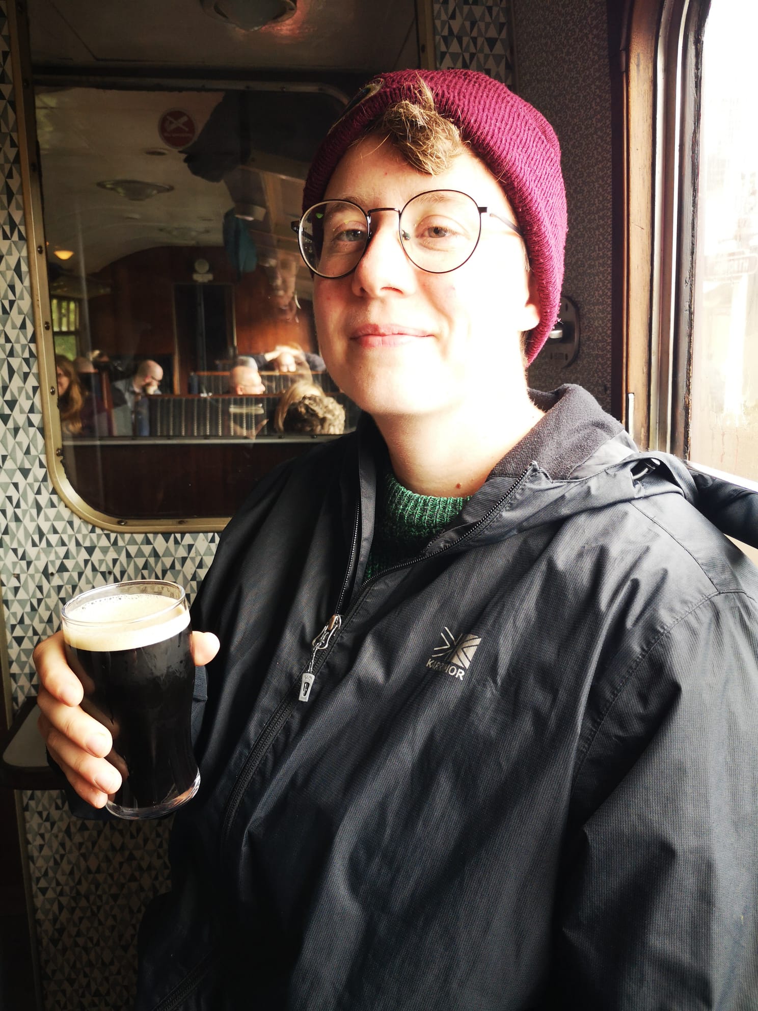 Me sipping stout on a steam train to Haworth.
